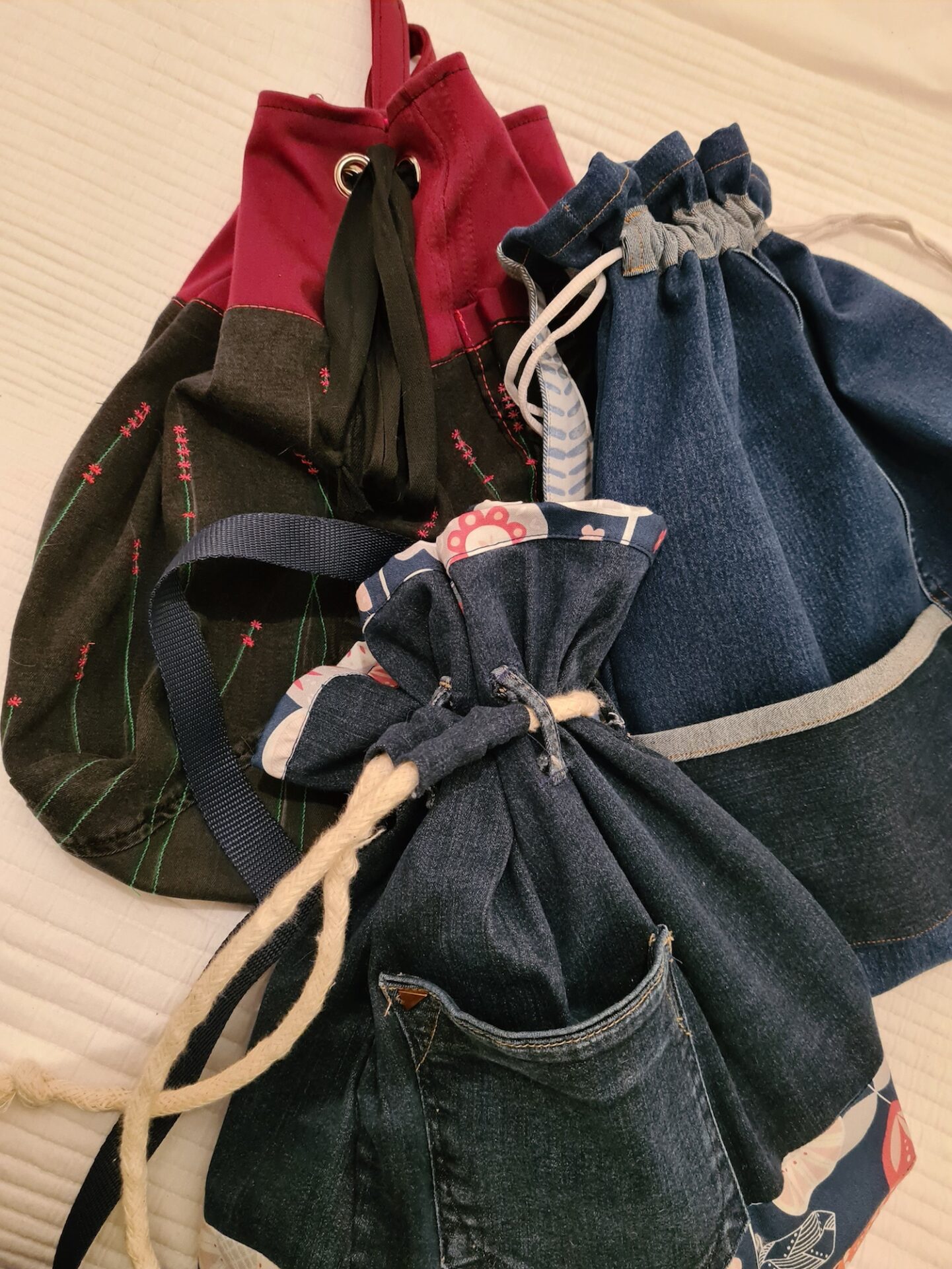 three duffel bags that have been fashioned from jeans