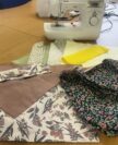Pieces on a table in front of a sewing machine.