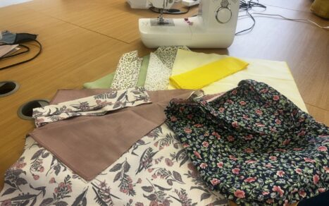 Pieces on a table in front of a sewing machine.