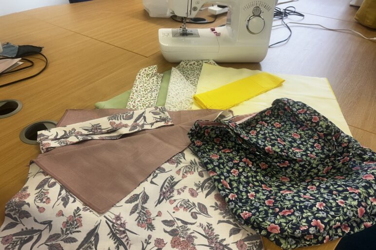 Pieces on a table in front of a sewing machine.